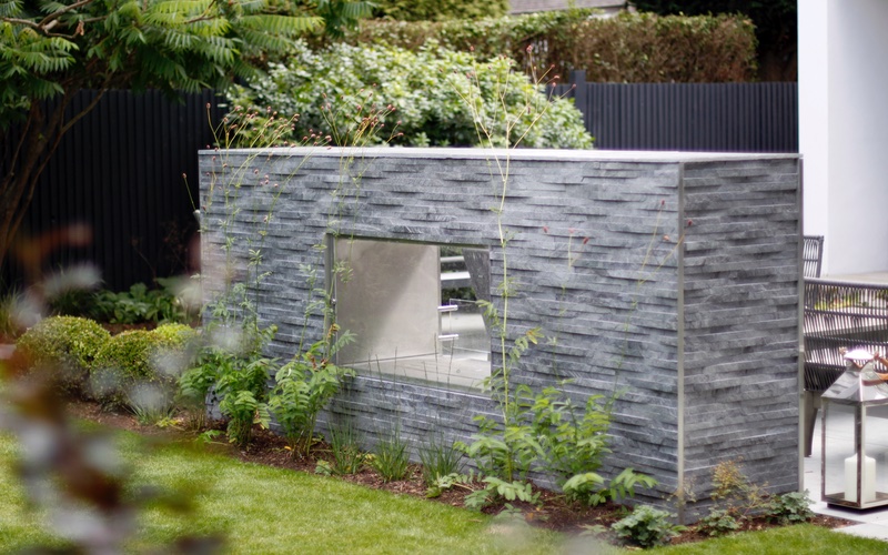 Textured cladding on fireplace, south west London garden.